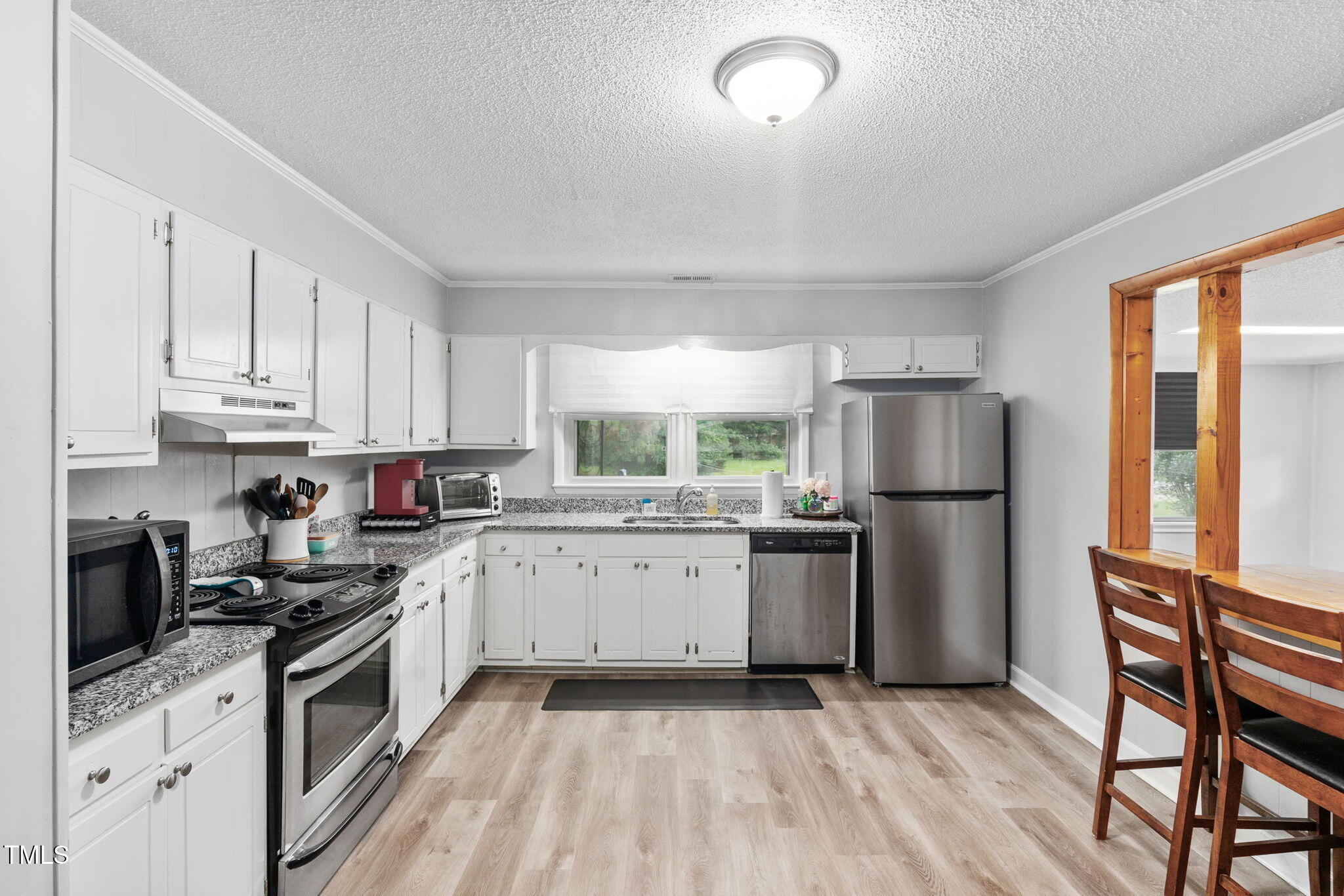 131 Biz Road Selma, NC 27576 - Photo 5 of 17 a kitchen with a refrigerator a stove top oven and white cabinets