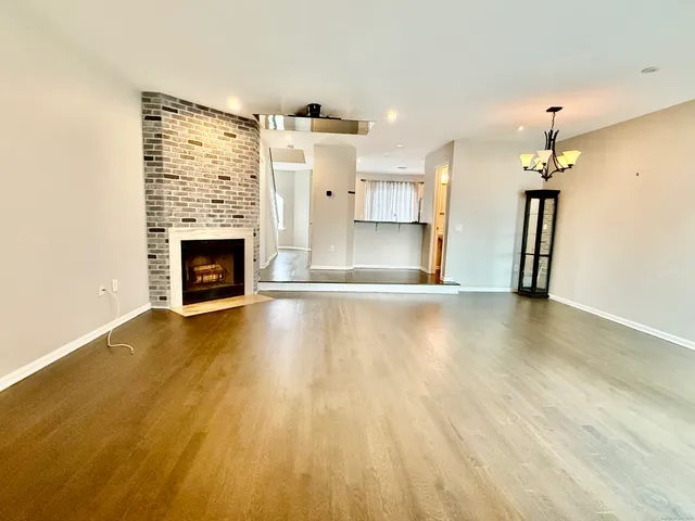 a view of a livingroom with fireplace and wooden floor
