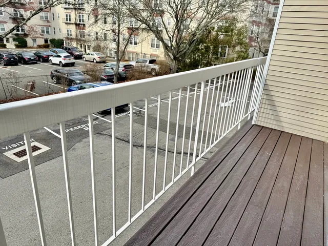 a view of a balcony with wooden floor and fence
