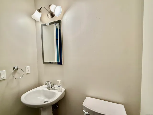 a bathroom with a toilet sink and mirror