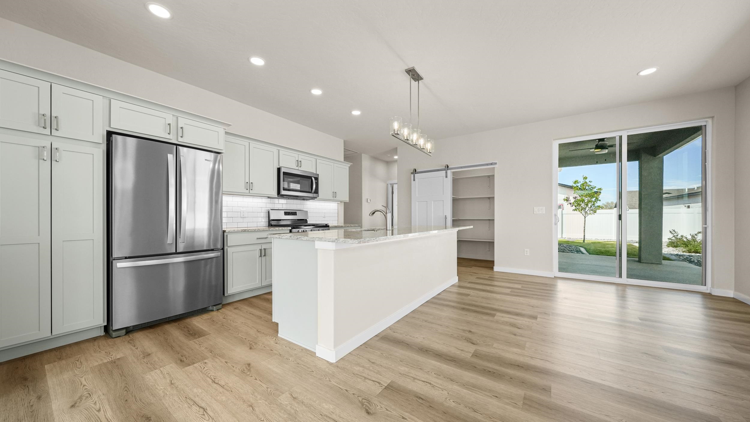 1705 Tungsten Way Fruita, CO 81521 - Photo 11 of 34 a large kitchen with stainless steel appliances a refrigerator and wooden floor