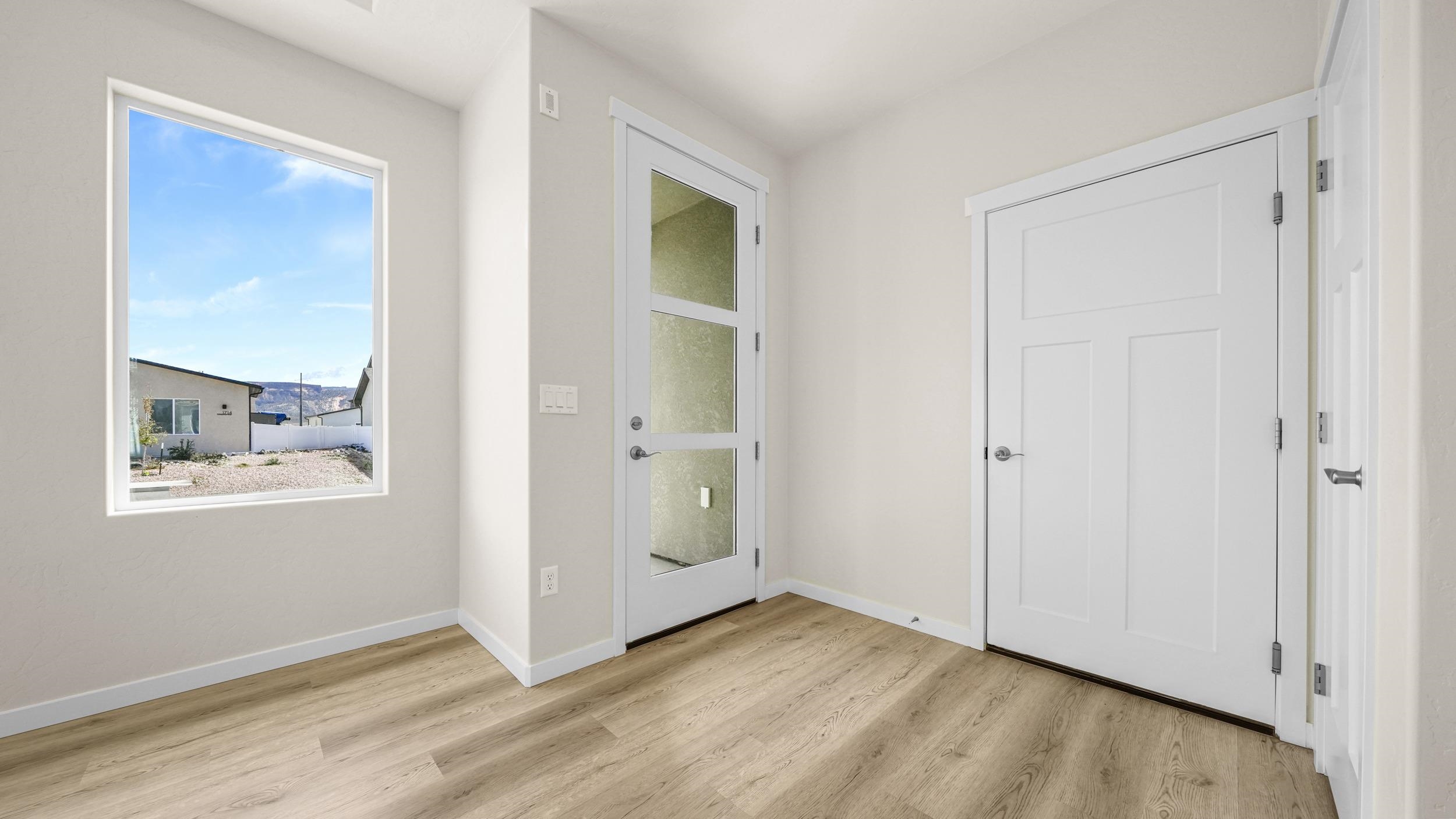 1705 Tungsten Way Fruita, CO 81521 - Photo 15 of 34 a view of an empty room with window and wooden floor