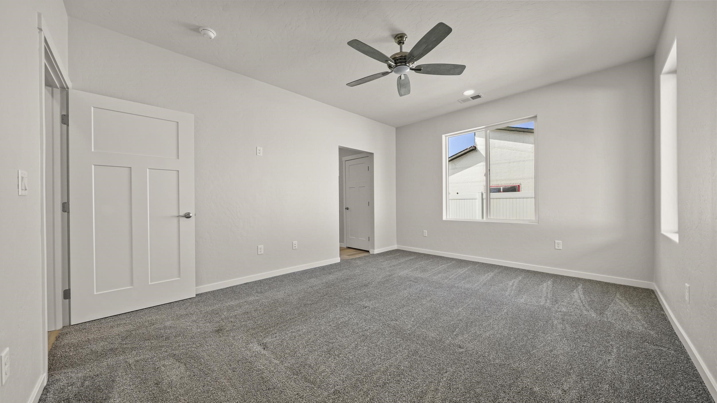 1705 Tungsten Way Fruita, CO 81521 - Photo 17 of 34 an empty room with windows and ceiling fan