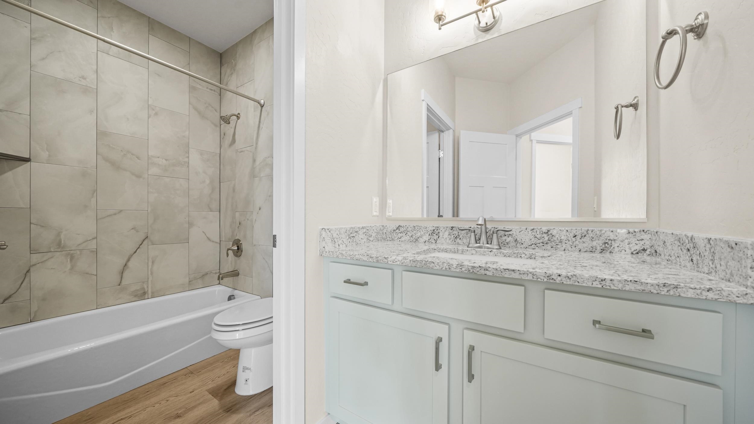 1705 Tungsten Way Fruita, CO 81521 - Photo 23 of 34 a bathroom with a granite countertop sink toilet and shower