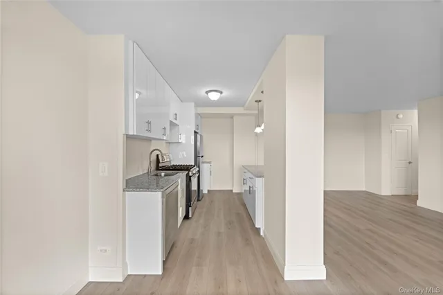 a view of a kitchen with a sink wooden floor and a window