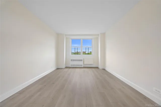 a view of a room with wooden floor and window
