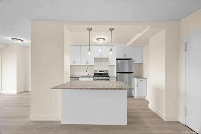 a large kitchen with cabinets stainless steel appliances and a counter space