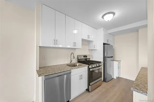 a kitchen with stainless steel appliances granite countertop a stove a refrigerator and a sink