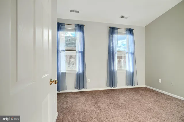 a view of a hallway with wooden floor and windows
