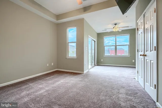 a view of empty room with front door and flat screen tv