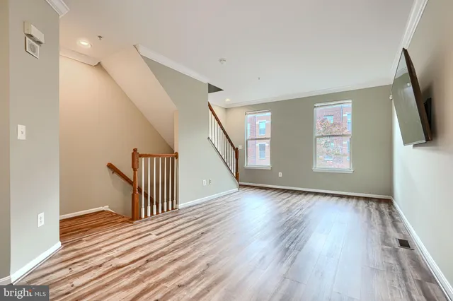 a view of a livingroom with wooden floor and stairs