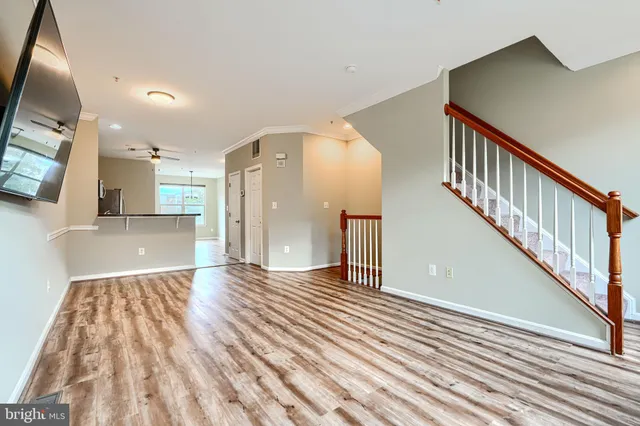 a view of a livingroom with wooden floor and stairs
