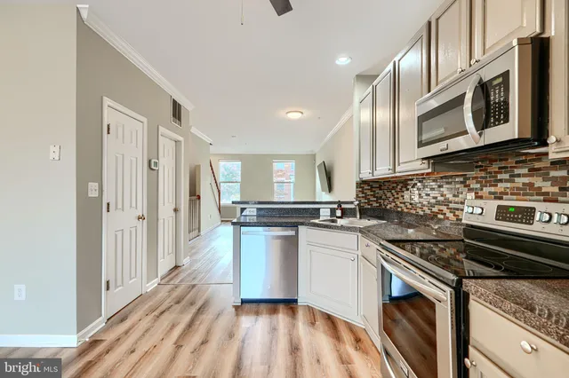 a kitchen with stainless steel appliances granite countertop a stove and a sink