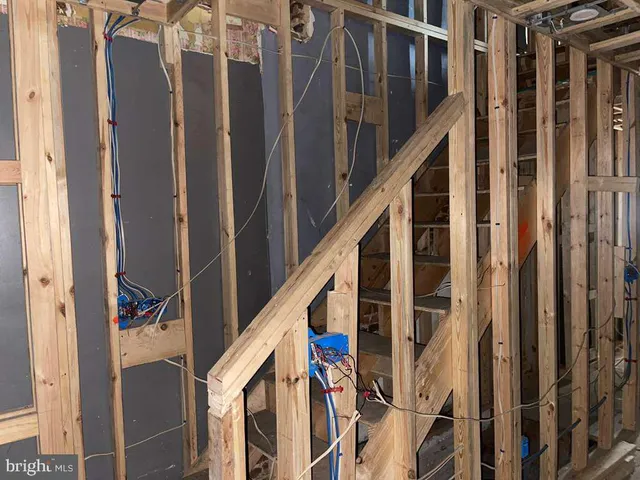a view of staircase with railing and white walls