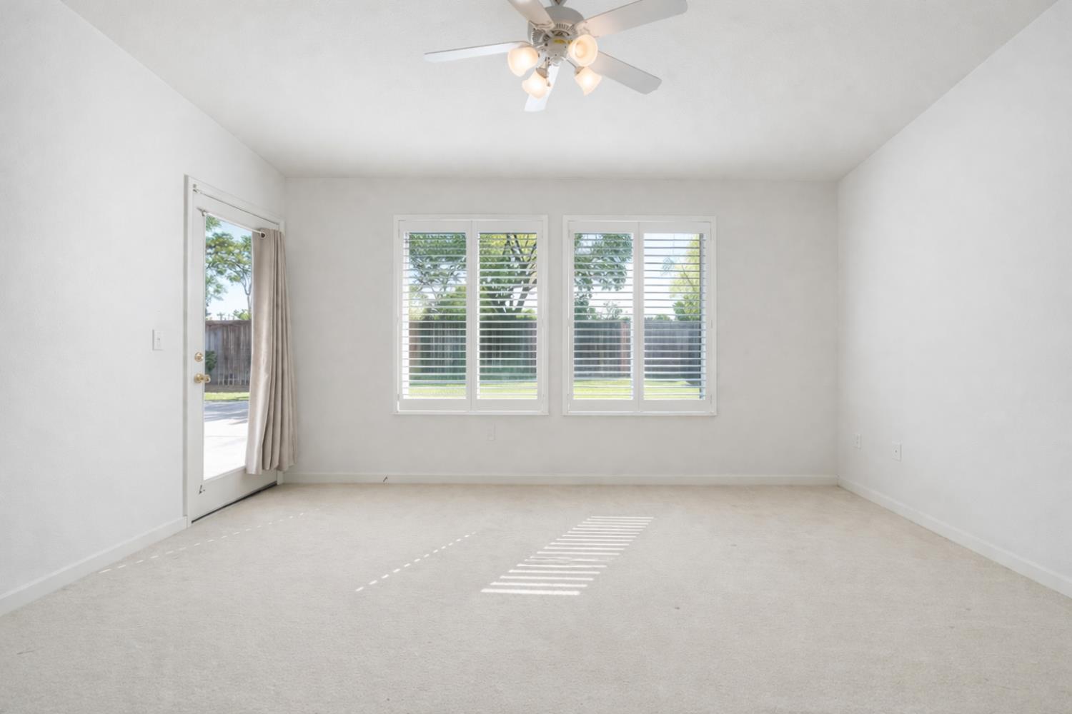 721 Via Cerioni Madera, CA 93637 - Photo 12 of 24 an empty room with chandelier fan and windows