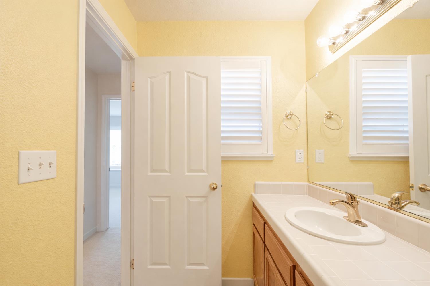 721 Via Cerioni Madera, CA 93637 - Photo 14 of 24 a bathroom with a sink and a mirror