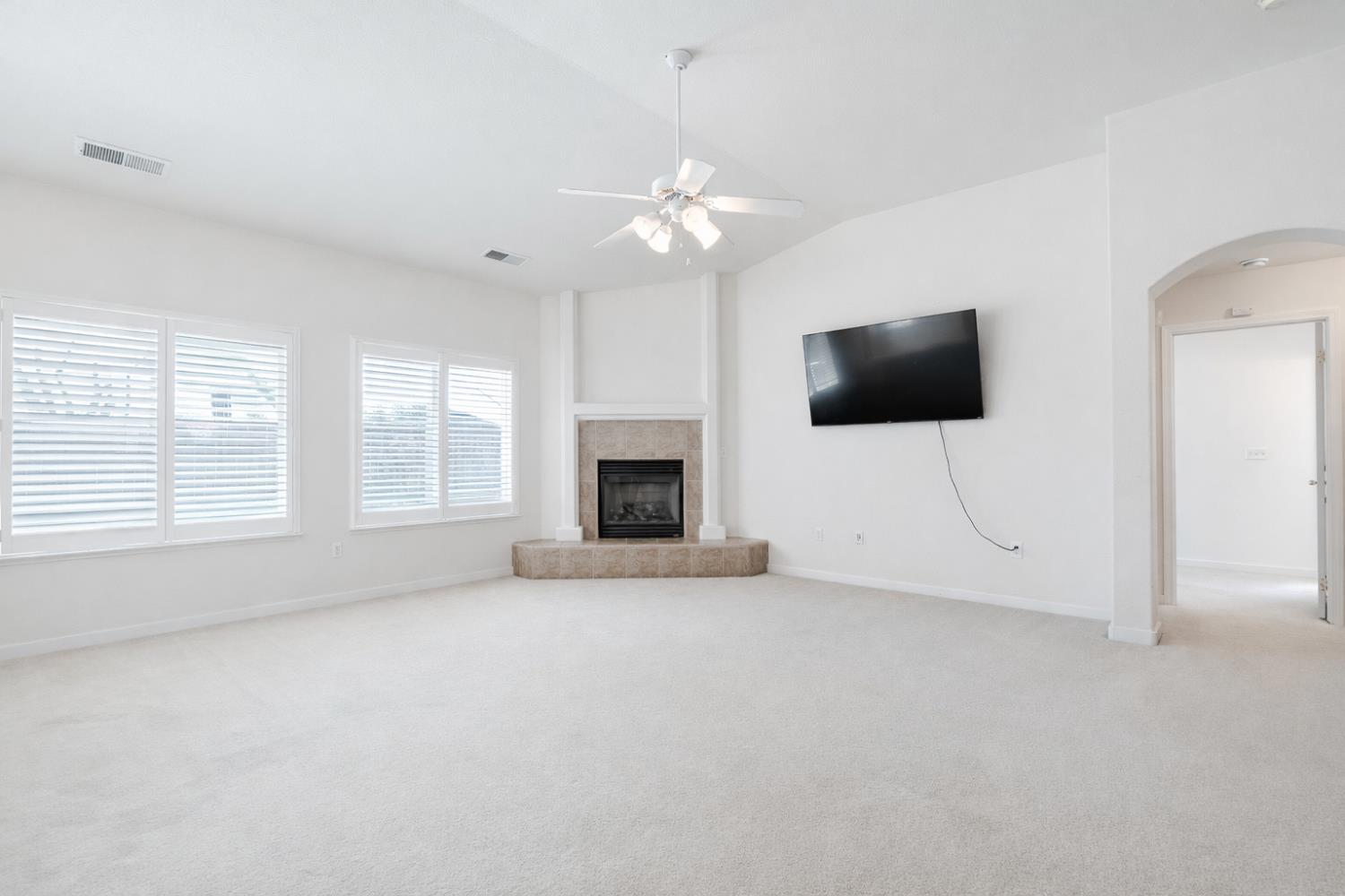 721 Via Cerioni Madera, CA 93637 - Photo 6 of 24 an empty room with a flat screen tv and a fireplace