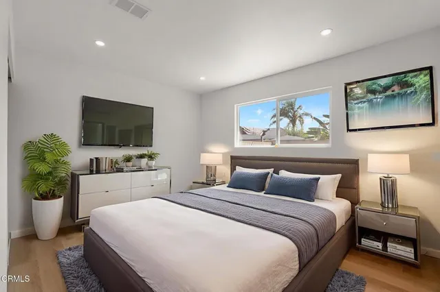 a bedroom with a large bed and a flat screen tv