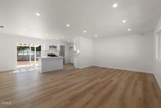 a view of a kitchen with wooden floor and windows