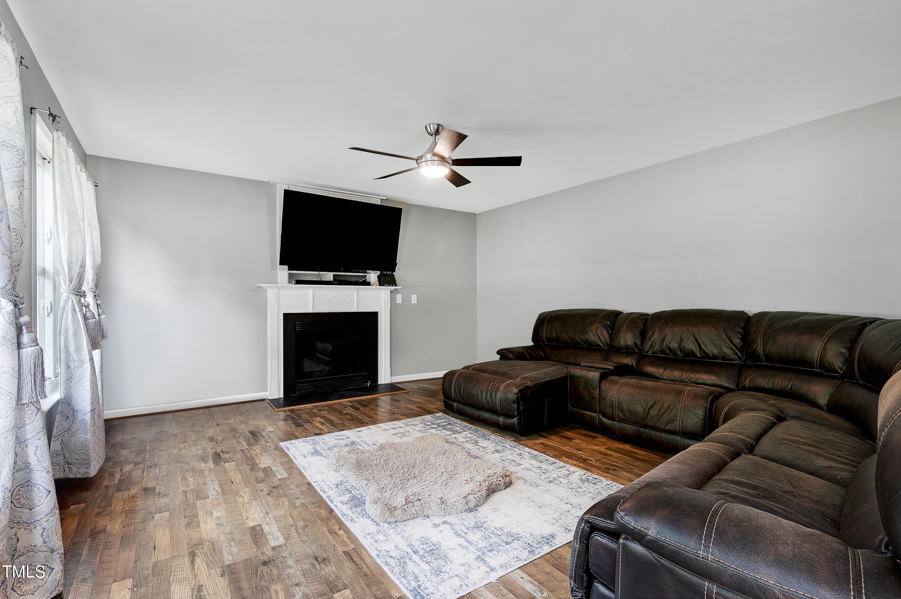 128 Lee Trace Drive Smithfield, NC 27577 - Photo 11 of 33 a living room with furniture a flat screen tv and a fireplace