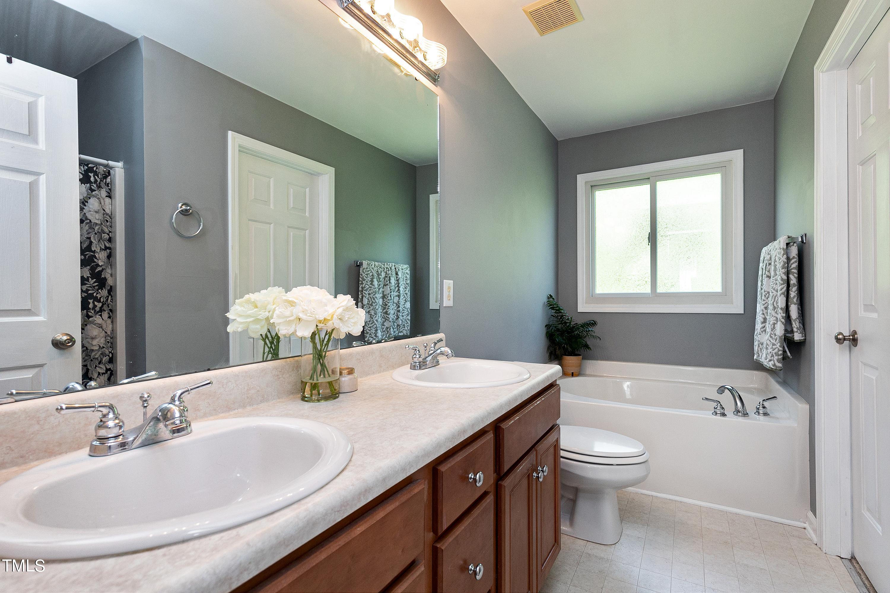 128 Lee Trace Drive Smithfield, NC 27577 - Photo 16 of 33 a bathroom with a granite countertop sink a toilet and bathtub