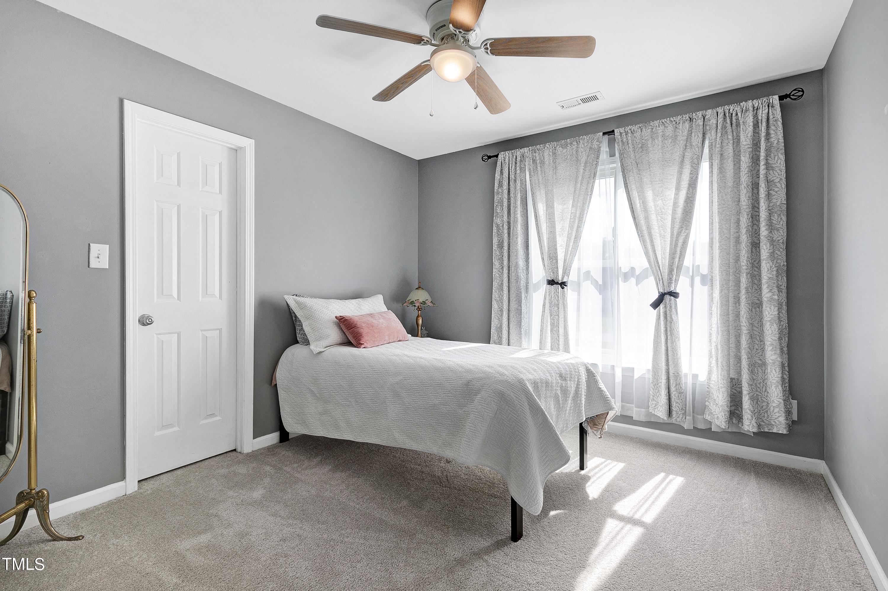 128 Lee Trace Drive Smithfield, NC 27577 - Photo 18 of 33 a spacious bedroom with a bed and a chandelier