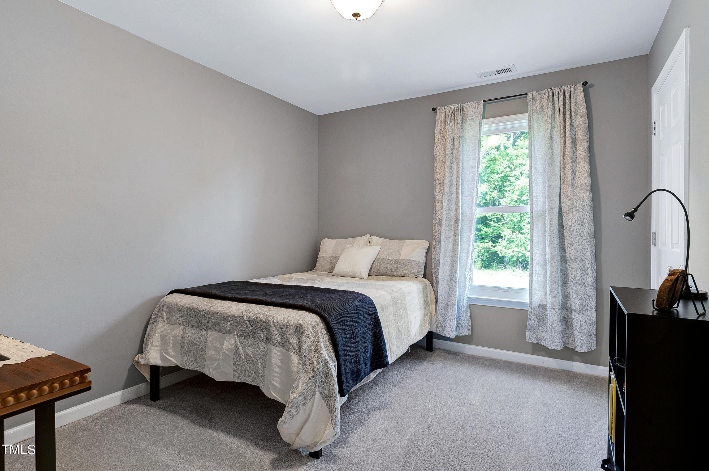 128 Lee Trace Drive Smithfield, NC 27577 - Photo 19 of 33 a bed sitting in a bedroom next to a window