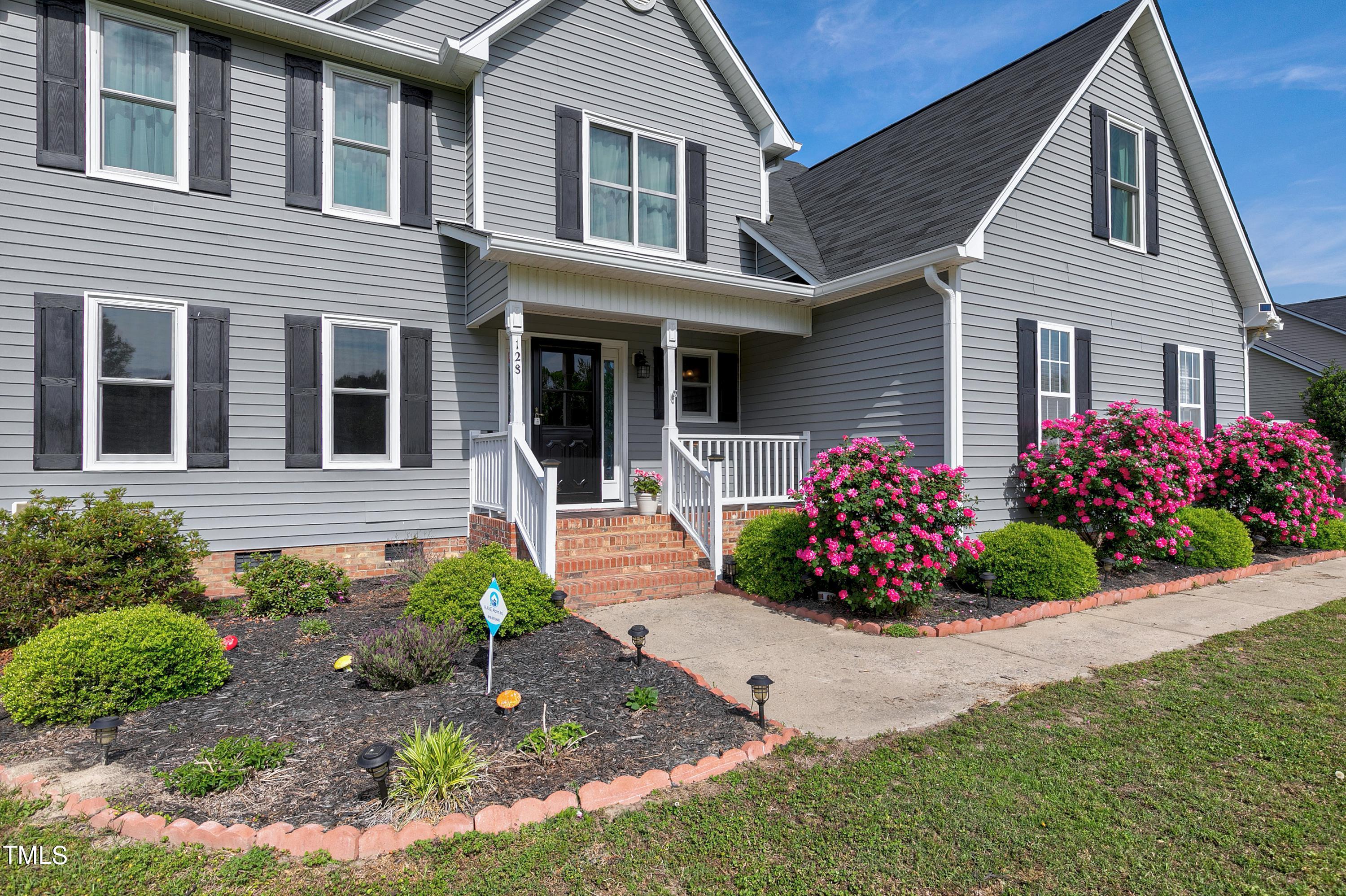 128 Lee Trace Drive Smithfield, NC 27577 - Photo 4 of 33 a front view of a house with a garden