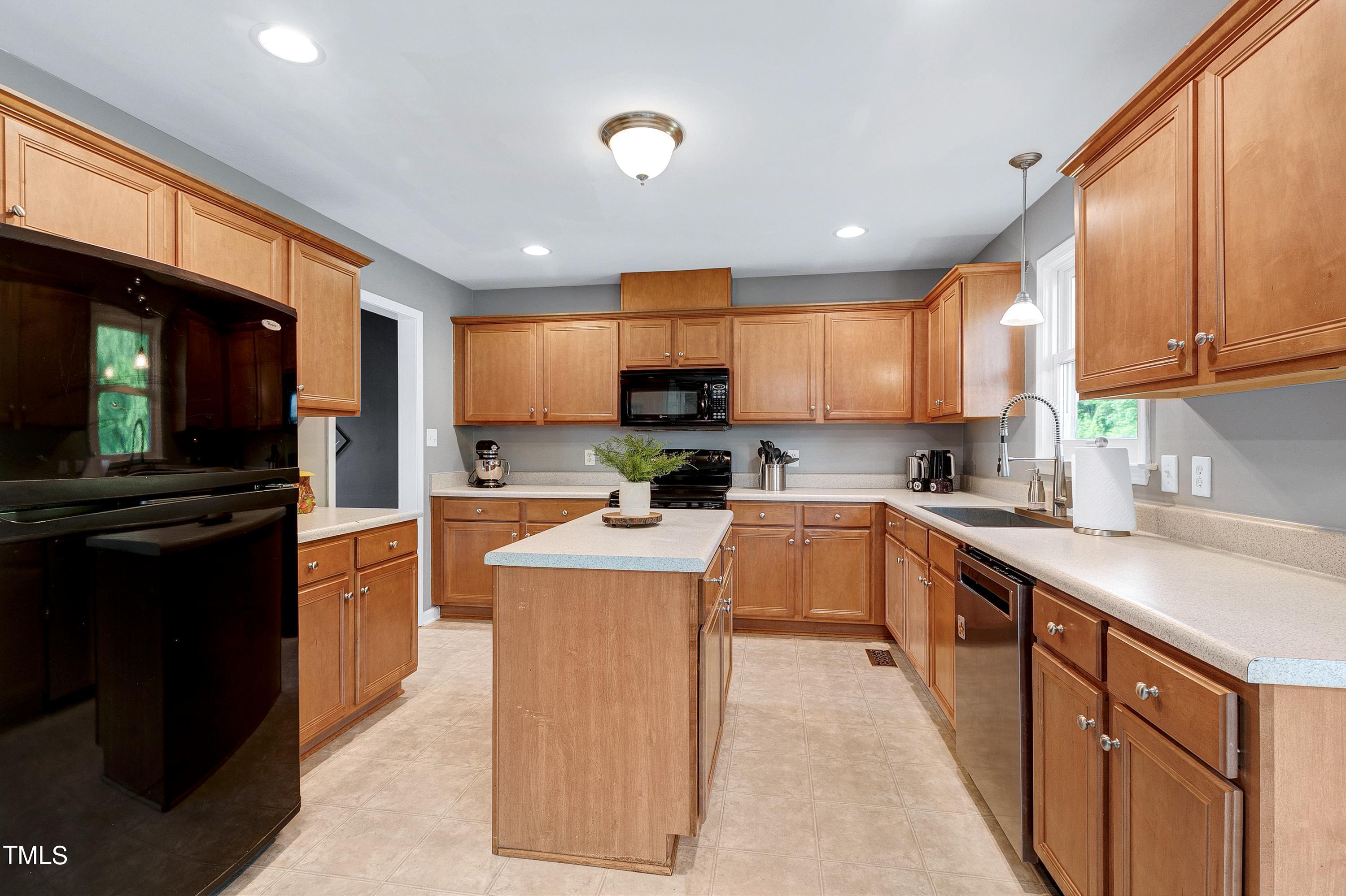 128 Lee Trace Drive Smithfield, NC 27577 - Photo 6 of 33 a kitchen with stainless steel appliances granite countertop wooden cabinets a sink a stove a refrigerator and a microwave