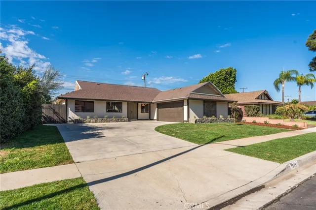 a front view of a house with a garden and yard
