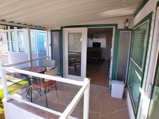 a view of a porch with furniture and floor to ceiling window