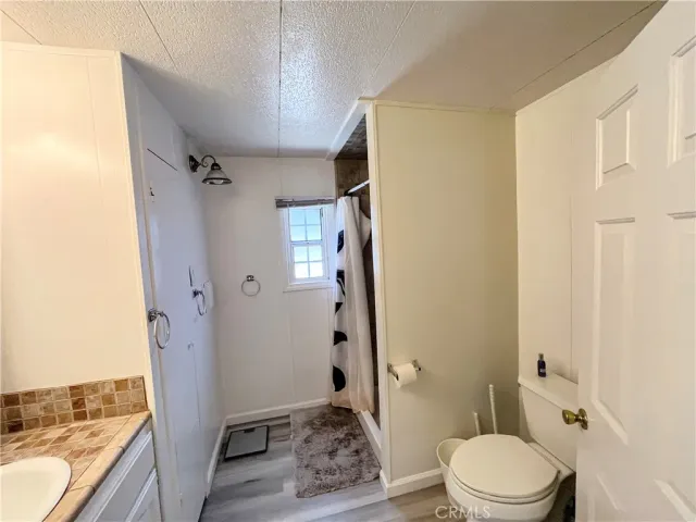 a bathroom with a granite countertop sink toilet and shower