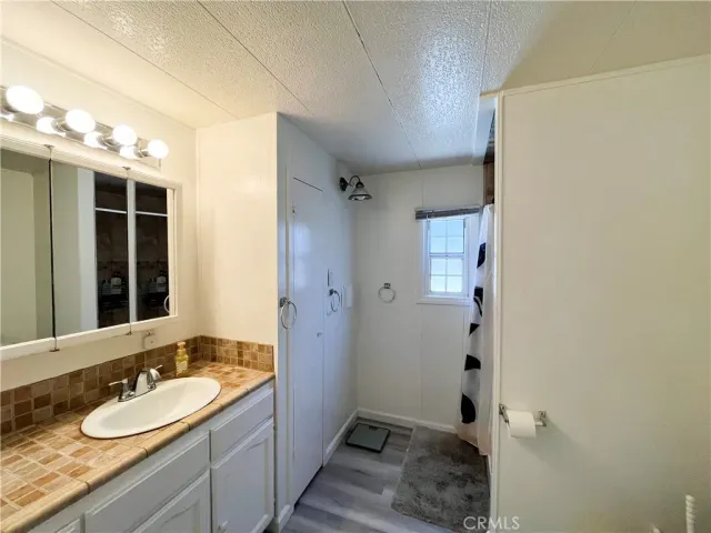 a bathroom with a granite countertop sink toilet and shower