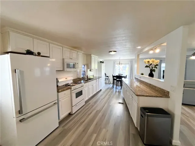 a large kitchen with cabinets wooden floor and stainless steel appliances