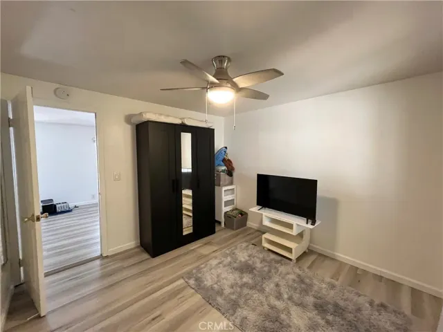 a living room with a flat screen tv and a ceiling fan