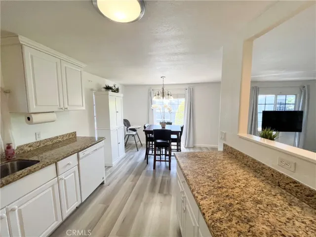 a kitchen with granite countertop white cabinets and stainless steel appliances