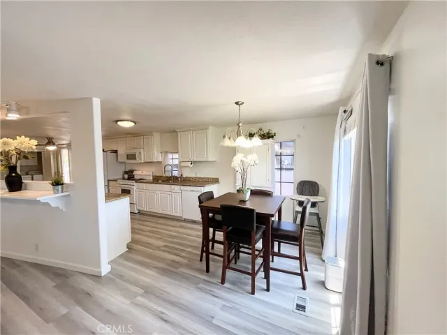 a kitchen with a dining table chairs and refrigerator