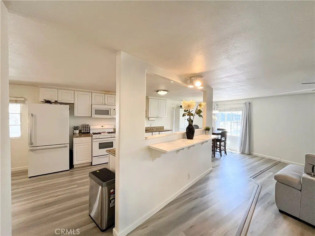 17700 Avalon, Unit 40 Carson, CA 90746 - Photo 6 of 33 a large white kitchen with cabinets wooden floor and a refrigerator