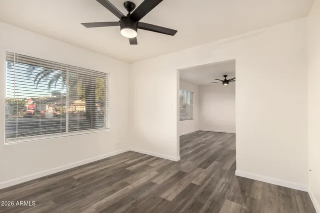 a view of empty room with wooden floor and fan