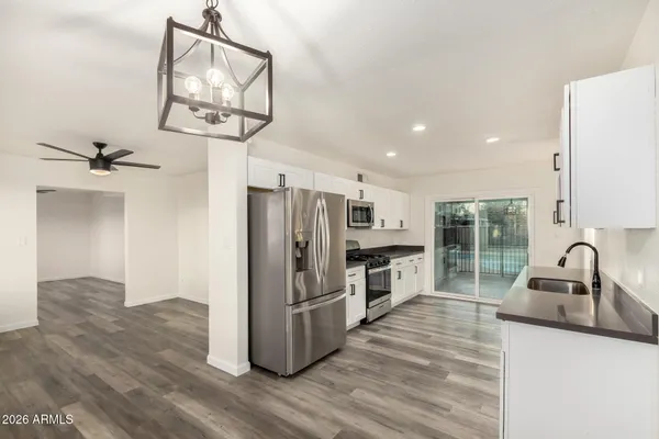 a kitchen with granite countertop a refrigerator and a sink