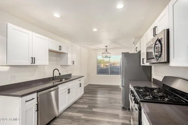 a kitchen with stainless steel appliances a sink stove and cabinets