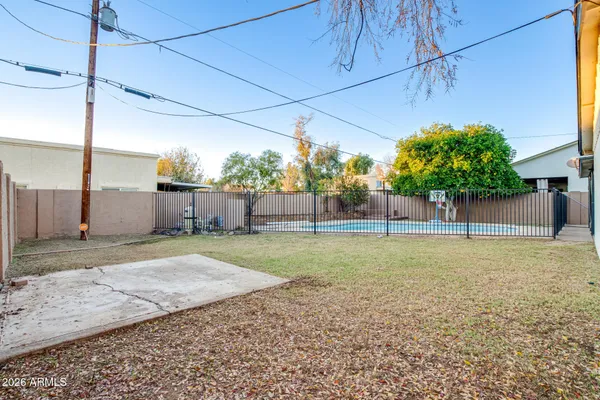 a backyard of a house with plants and large trees