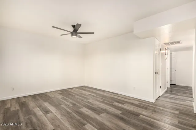 a view of a room with wooden floor and a ceiling fan