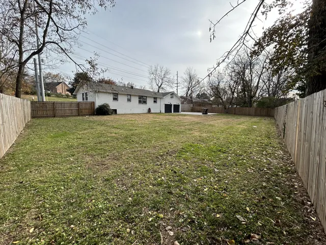 a backyard of a house with lots of green space and fountain