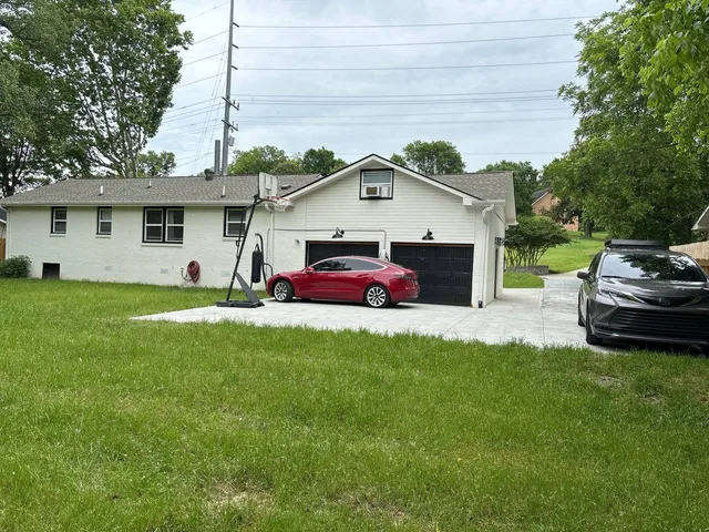 a front view of a house with a garden and trees