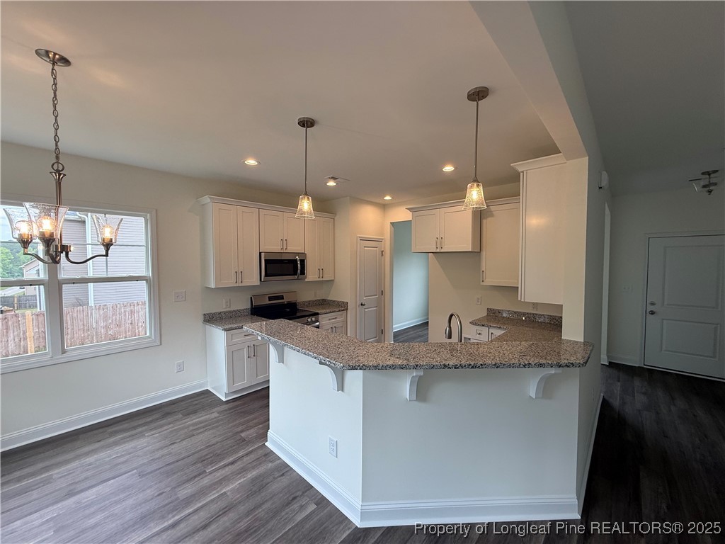 81 Reece Drive Sanford, NC 27332 - Photo 4 of 18 a kitchen with kitchen island granite countertop a sink a counter space appliances and a window