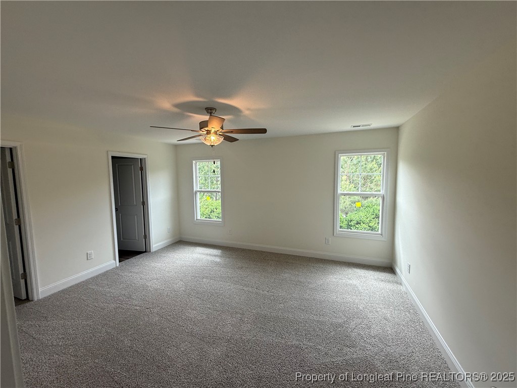 81 Reece Drive Sanford, NC 27332 - Photo 9 of 18 an empty room with windows and chandelier fan