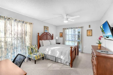 a bedroom with a bed couch tv and a window