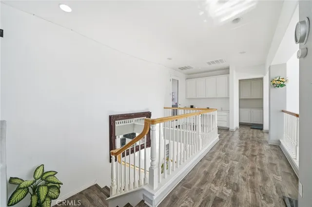 a view of a hallway with wooden floor and entryway