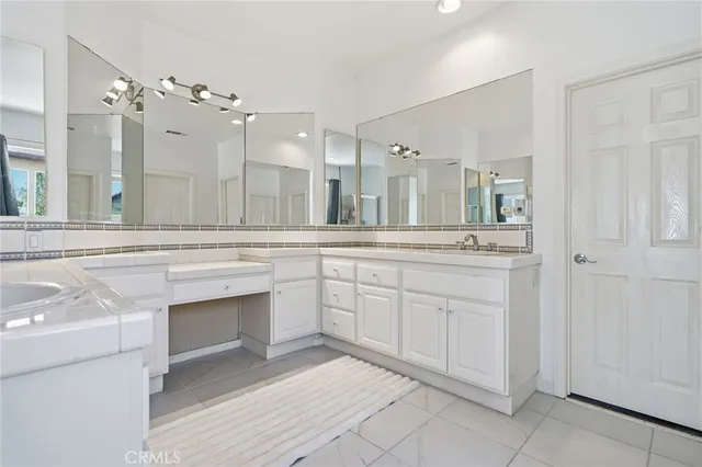 a spacious bathroom with a sink a mirror and a bathtub